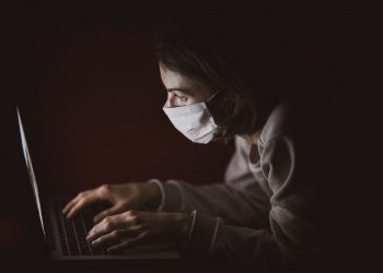 woman wearing mask and using computer