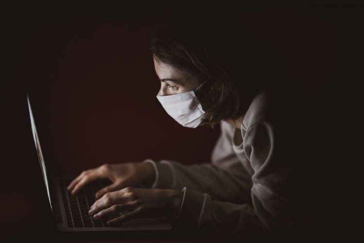 woman wearing mask and using computer